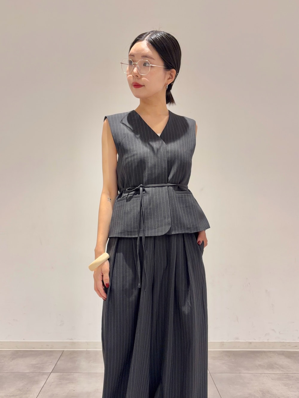 グレー系のダウンベスト、グレー系のその他パンツ、ブラック系のサンダルを着用したレディースの夏コーディネートの2枚目の写真
