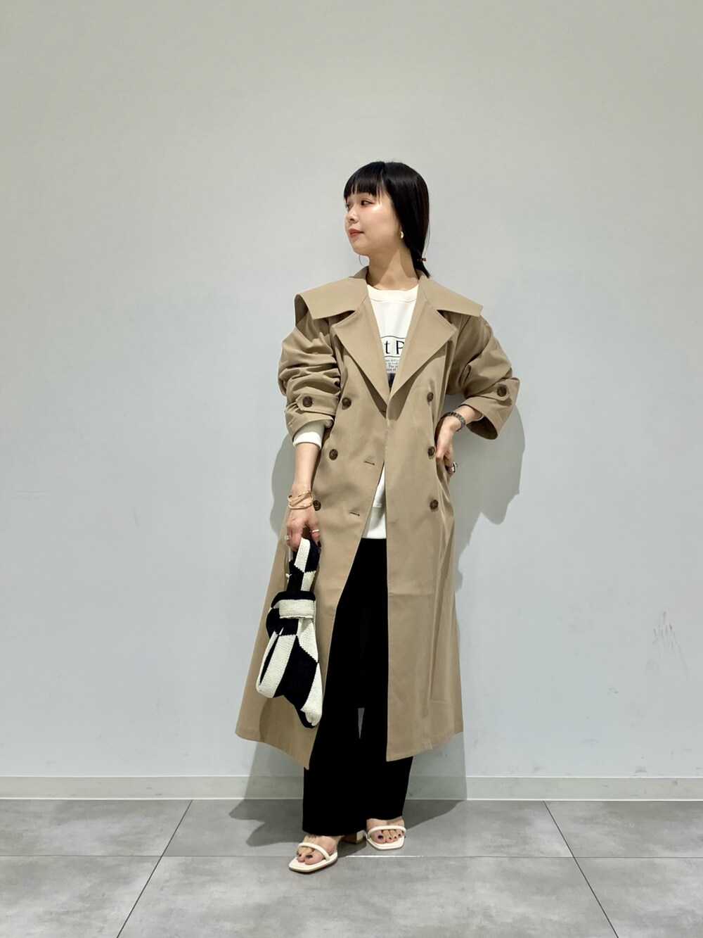 ホワイト系のサンダル、ベージュ系のトレンチコート、その他のスウェットを着用したレディースの春コーディネートの2枚目の写真