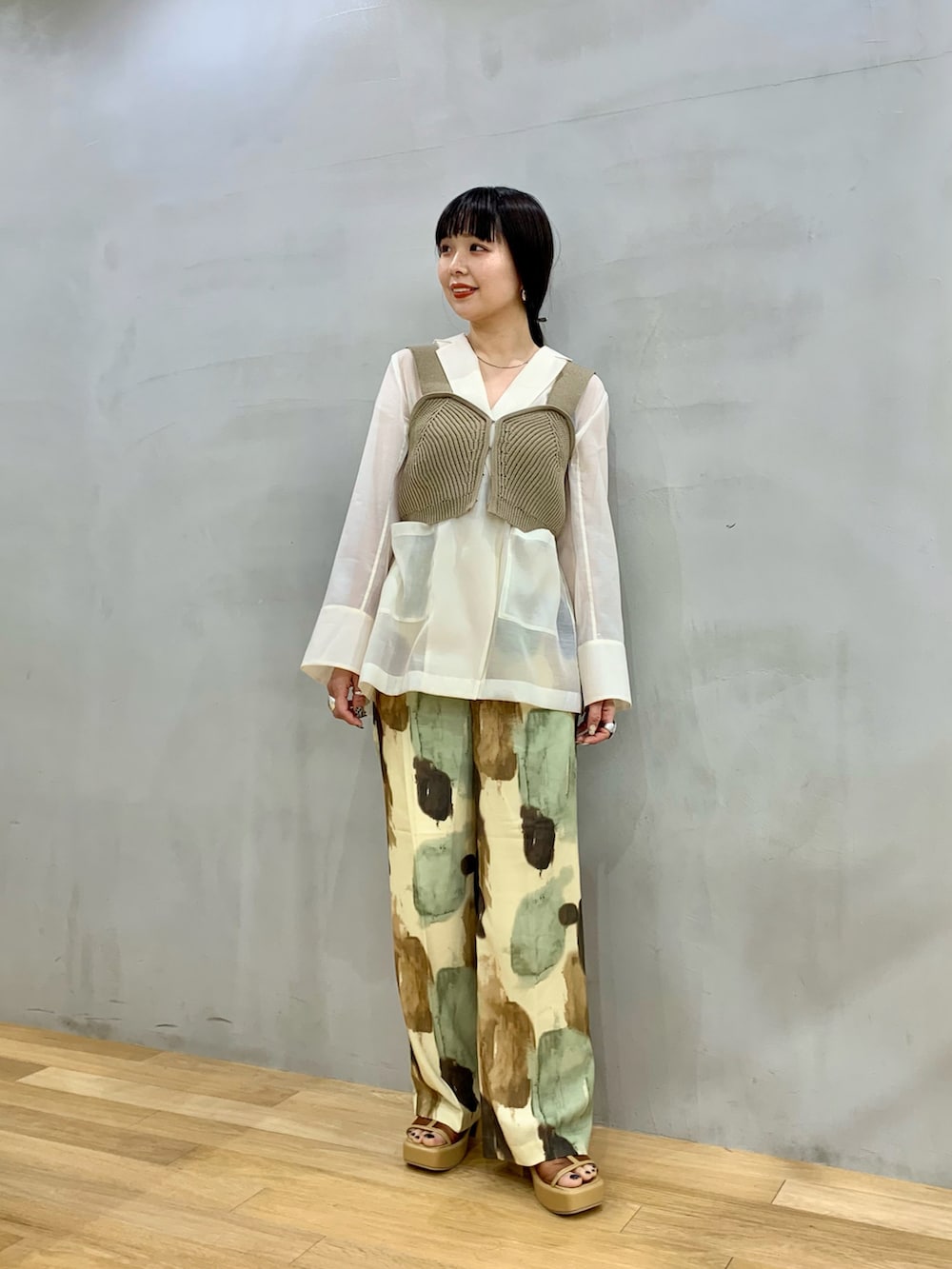 ホワイト系のその他アウター、イエロー系のその他パンツ、ブラック系のニット/セーターを着用したレディースの春コーディネートの2枚目の写真