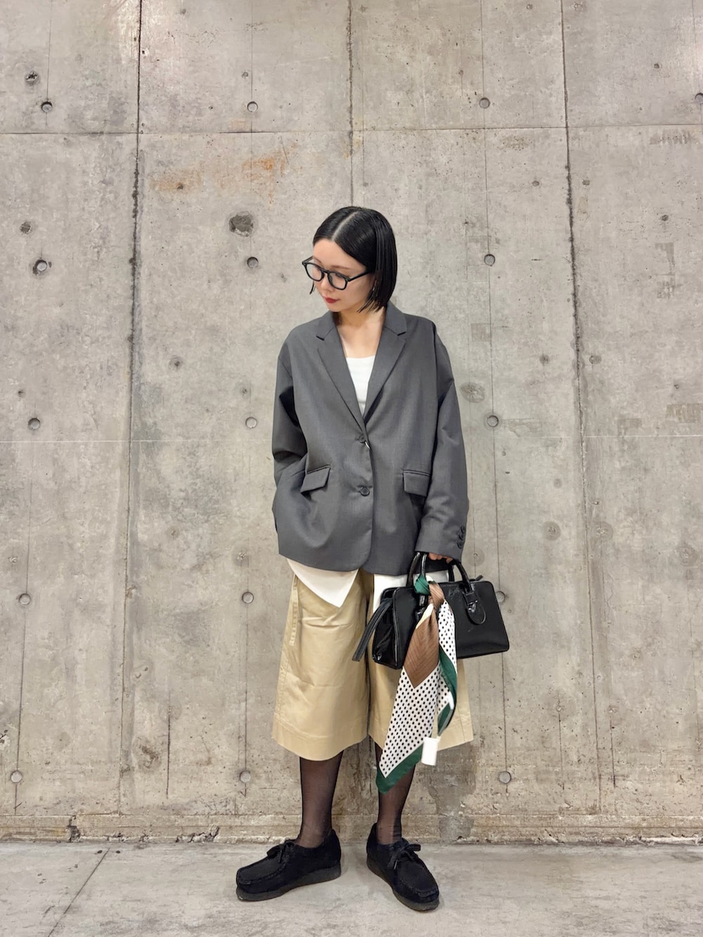 グレー系のその他アウター、ベージュ系のその他パンツ、ブラック系のボストンバッグを着用したレディースの春コーディネートの3枚目の写真