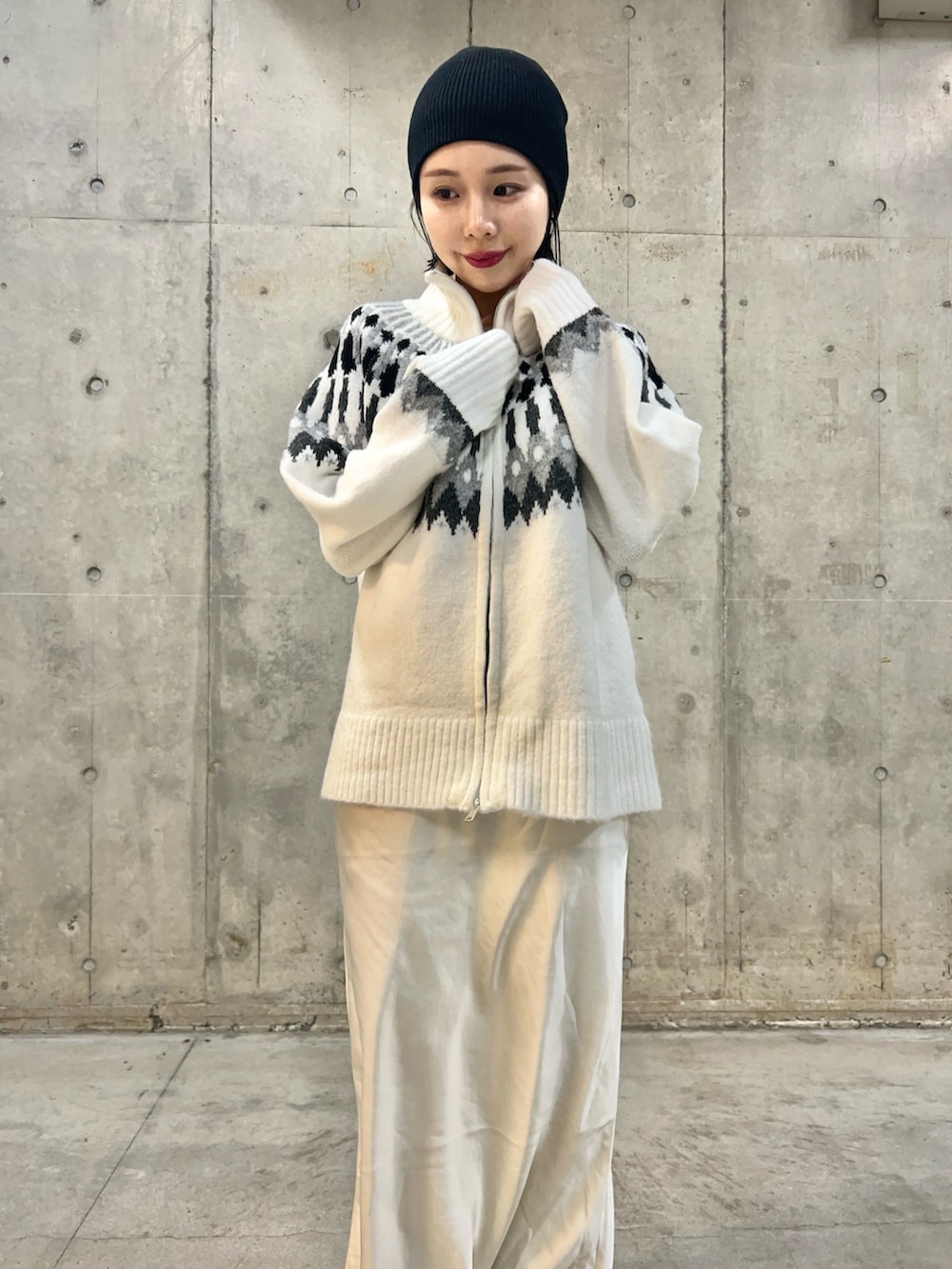 ホワイト系のニット/セーター、ホワイト系のスカートを着用したレディースの冬コーディネートの2枚目の写真