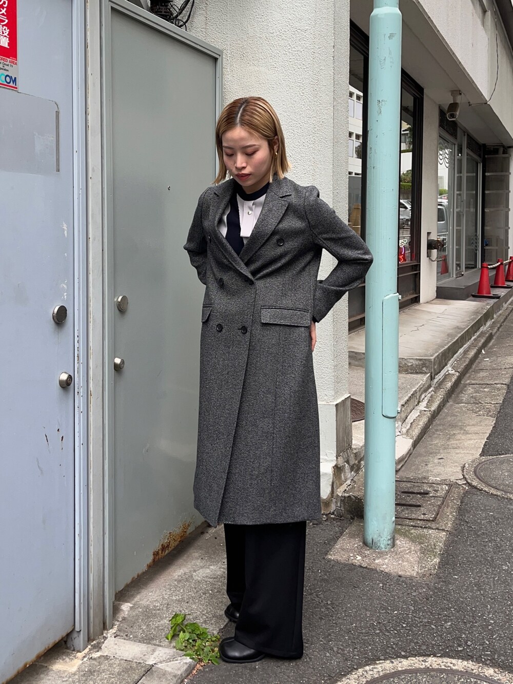 グレー系のチェスターコートを着用したレディースの秋コーディネートの3枚目の写真