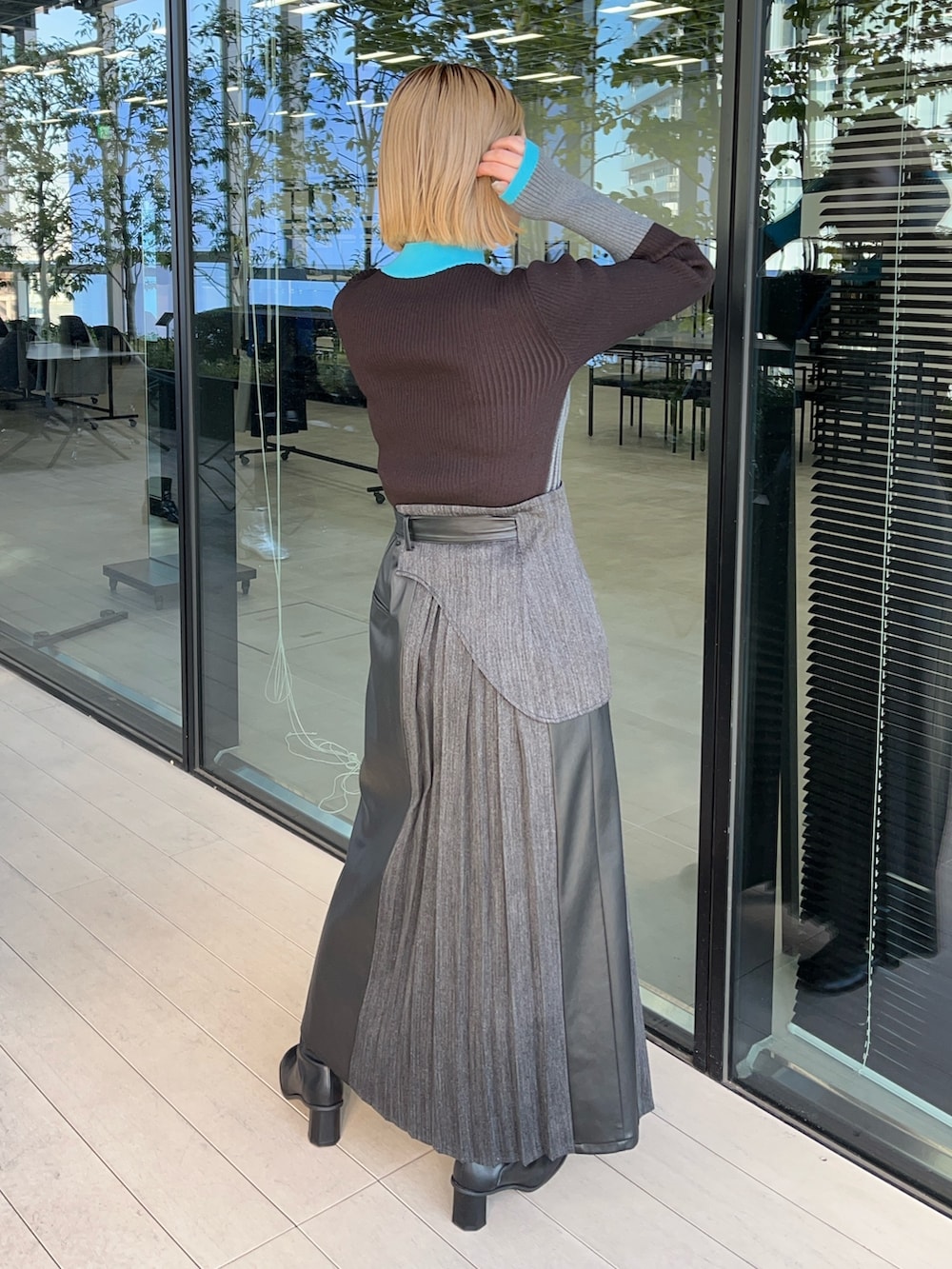 ブラウン系のニット/セーター、ブラック系のスカートを着用したレディースの冬コーディネートの2枚目の写真