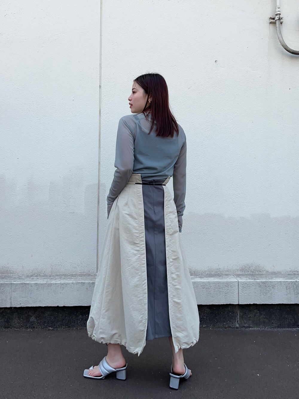 グリーン系のTシャツ/カットソー、ベージュ系のスカートを着用したレディースの春コーディネートの3枚目の写真