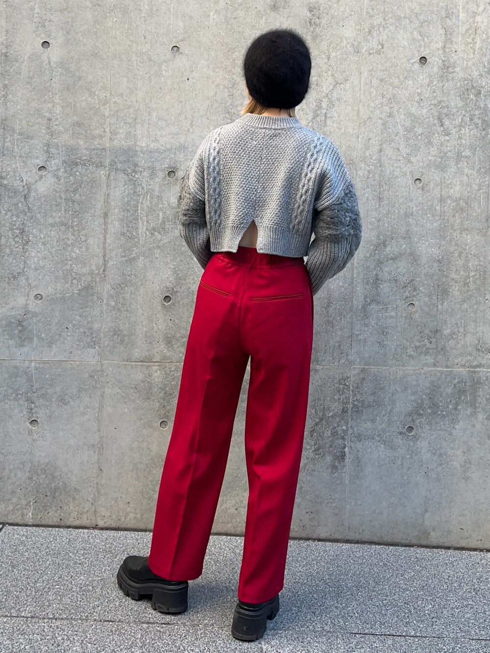 グレー系のニット/セーター、レッド系のその他パンツを着用したレディースの冬コーディネートの3枚目の写真