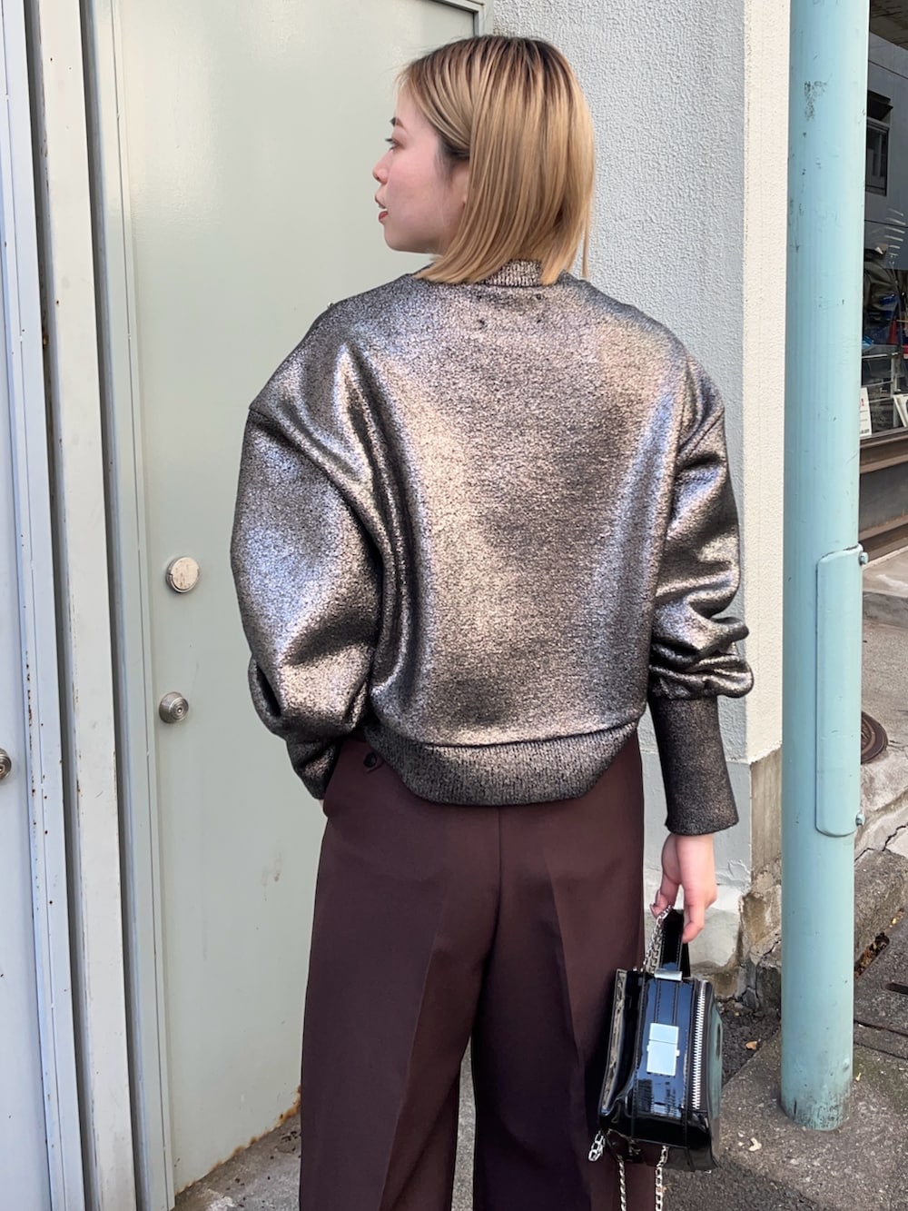 シルバー系のニット/セーター、ブラック系のショルダーバッグ、シルバー系のブーツを着用したレディースの冬コーディネートの5枚目の写真