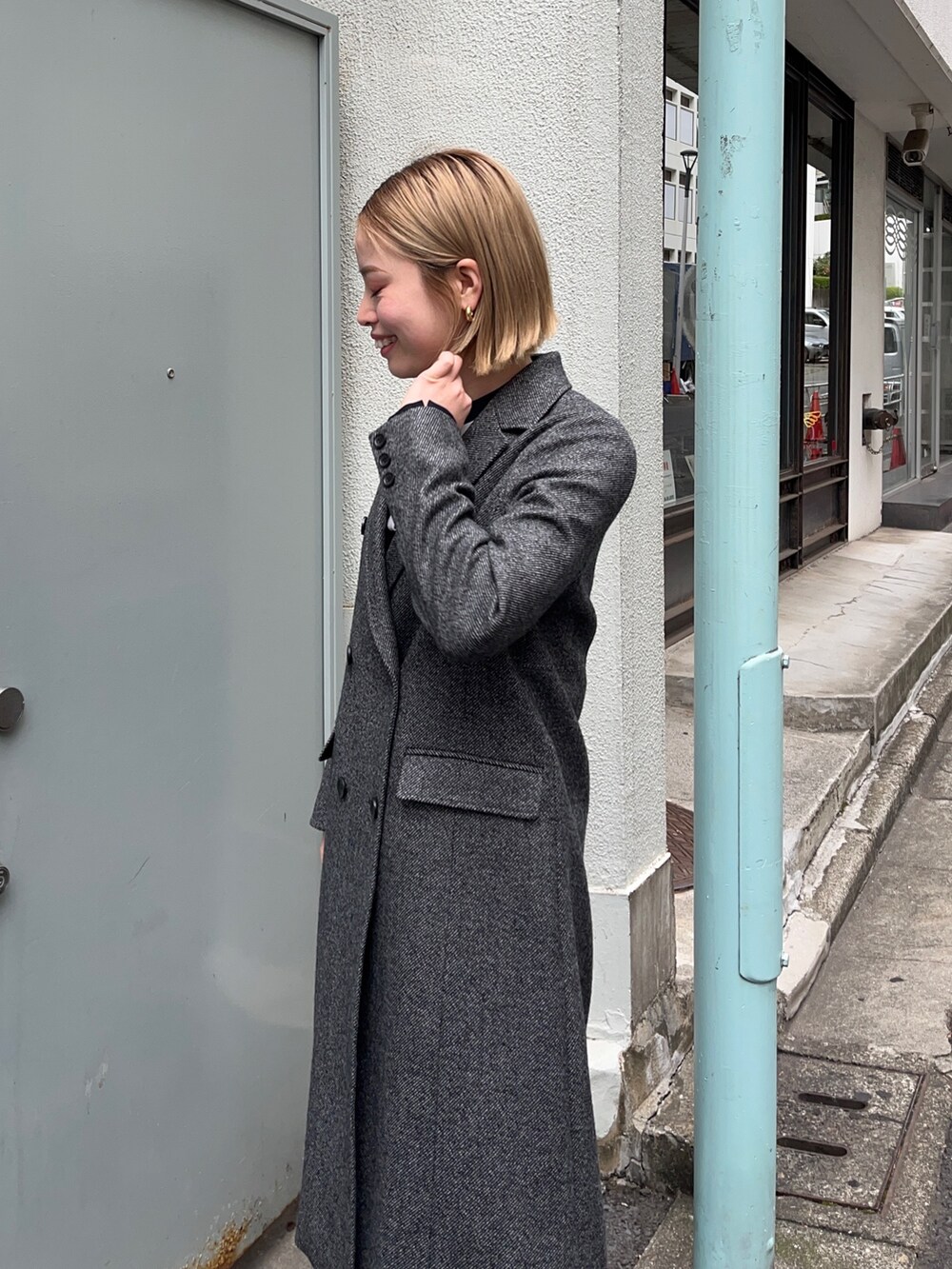 グレー系のチェスターコートを着用したレディースの秋コーディネートの5枚目の写真