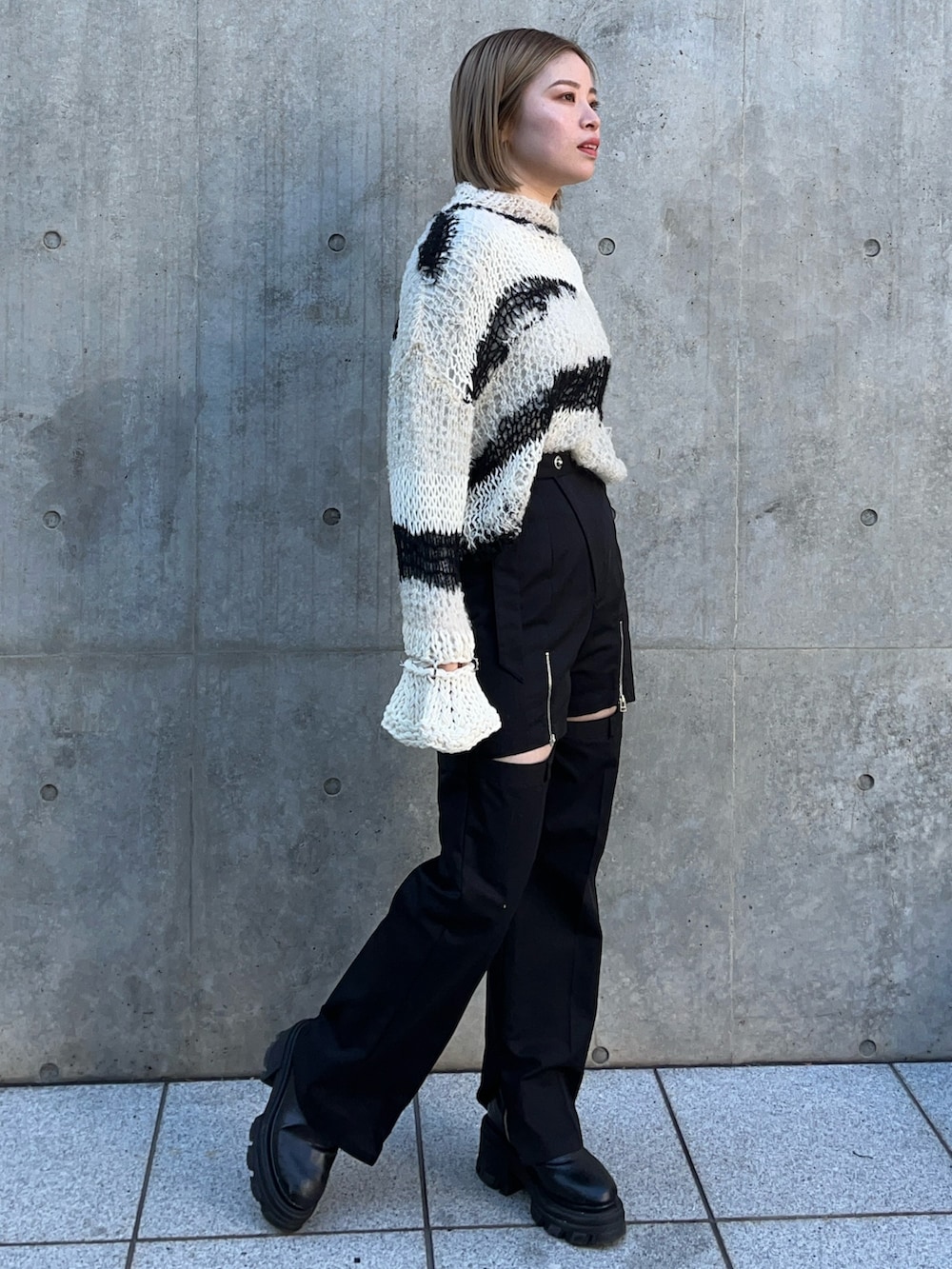 ホワイト系のニット/セーター、ブラック系のその他パンツを着用したレディースの冬コーディネートの2枚目の写真