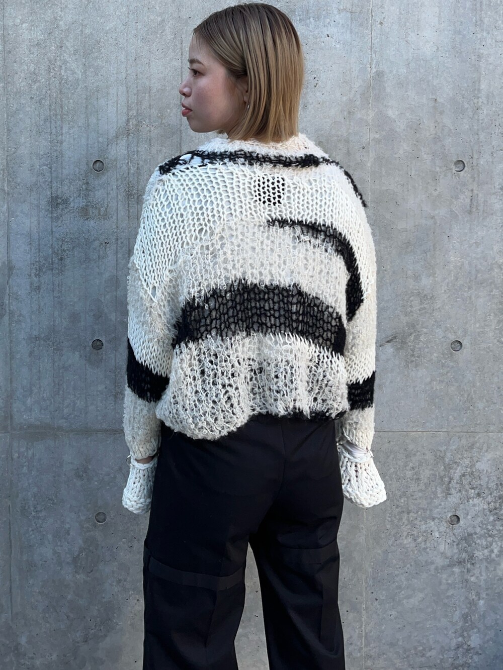 ホワイト系のニット/セーター、ブラック系のその他パンツを着用したレディースの冬コーディネートの5枚目の写真