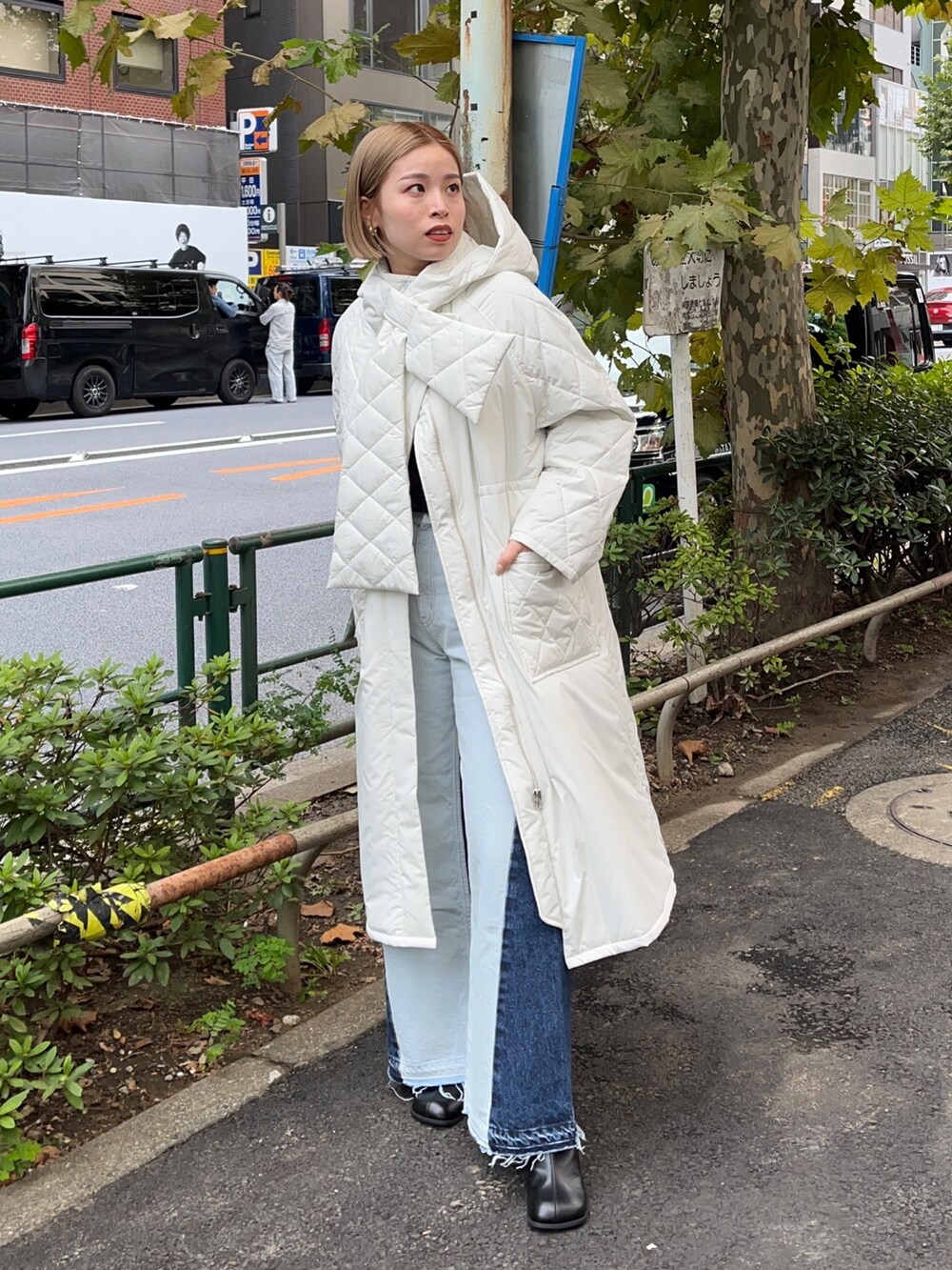 ホワイト系のダウンジャケット/コート、ブルー系のデニムパンツ、ブラウン系のニット/セーターを着用したレディースの秋コーディネートの2枚目の写真