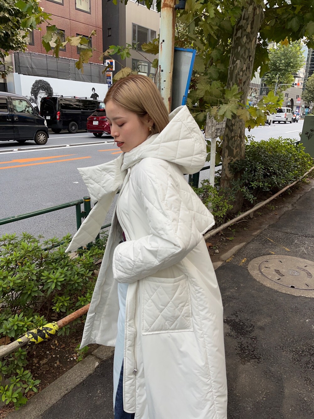 ホワイト系のダウンジャケット/コート、ブルー系のデニムパンツ、ブラウン系のニット/セーターを着用したレディースの秋コーディネートの6枚目の写真