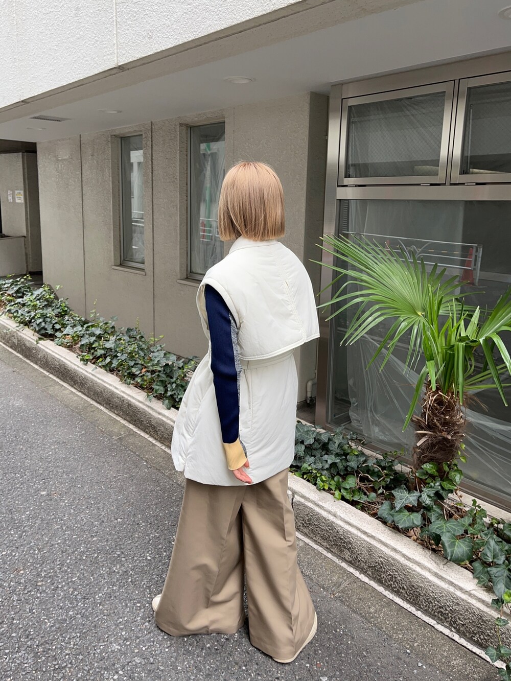 ホワイト系のダウンジャケット/コート、グレー系のニット/セーター、ベージュ系のチノパンツを着用したレディースの秋コーディネートの4枚目の写真