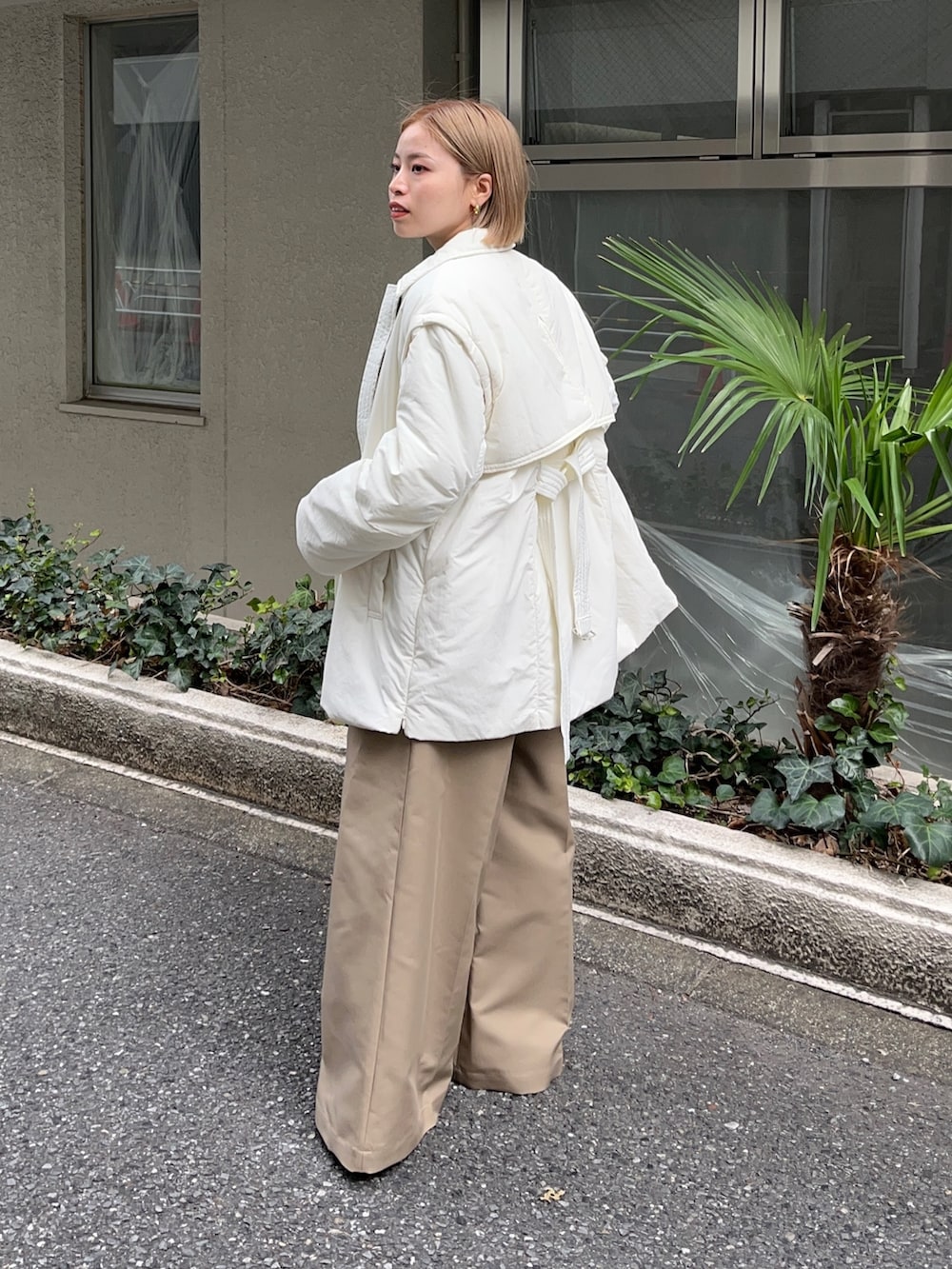 ホワイト系のダウンジャケット/コート、グレー系のニット/セーター、ベージュ系のチノパンツを着用したレディースの秋コーディネートの2枚目の写真