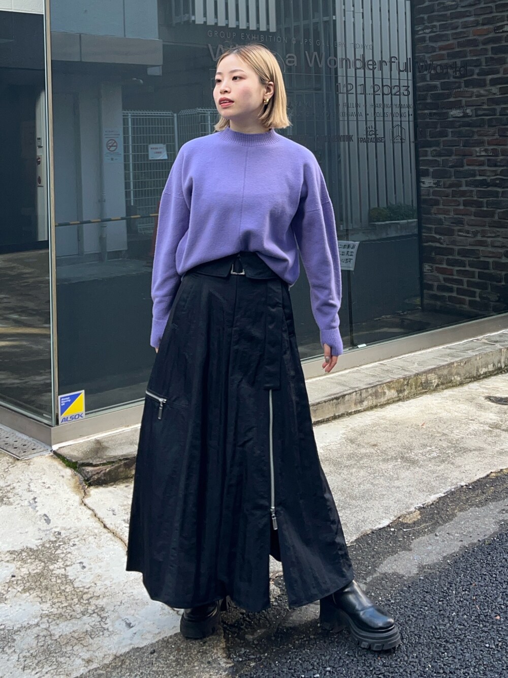 パープル系のニット/セーター、ブラック系のスカートを着用したレディースの冬コーディネートの3枚目の写真