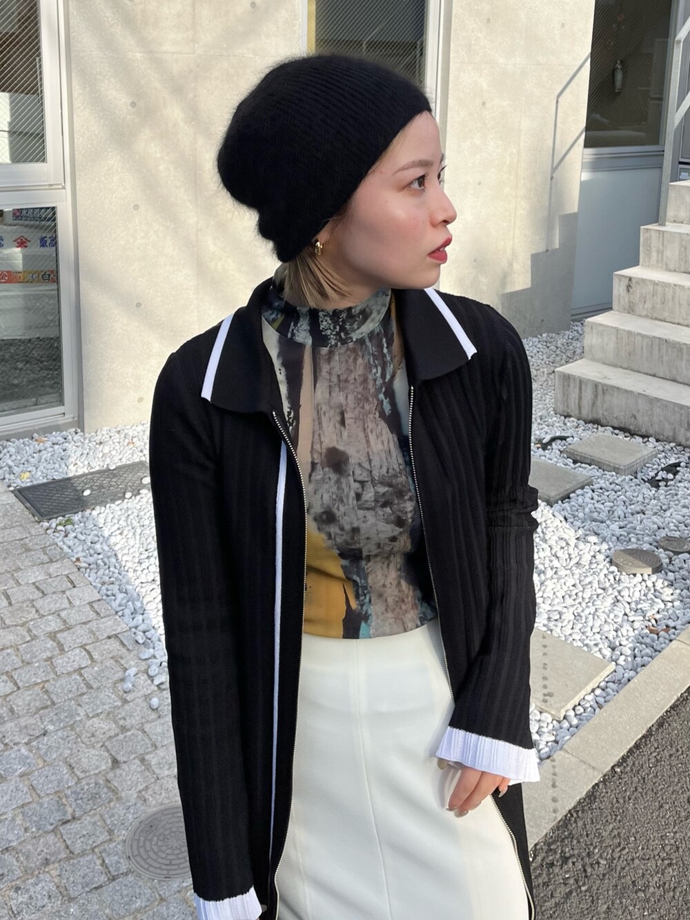 ブラウン系のTシャツ/カットソー、ブラック系のワンピース、ホワイト系のスカートを着用したレディースの冬コーディネートの3枚目の写真