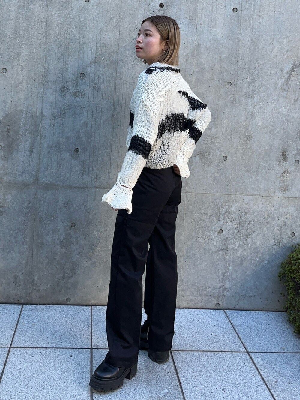 ホワイト系のニット/セーター、ブラック系のその他パンツを着用したレディースの冬コーディネートの4枚目の写真