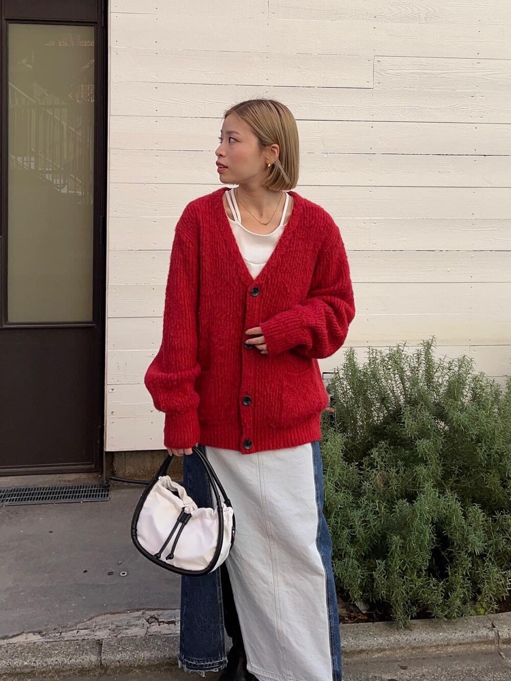 レッド系のカーディガン/ボレロ、ホワイト系のTシャツ/カットソー、ブルー系のスカートを着用したレディースの秋コーディネートの2枚目の写真