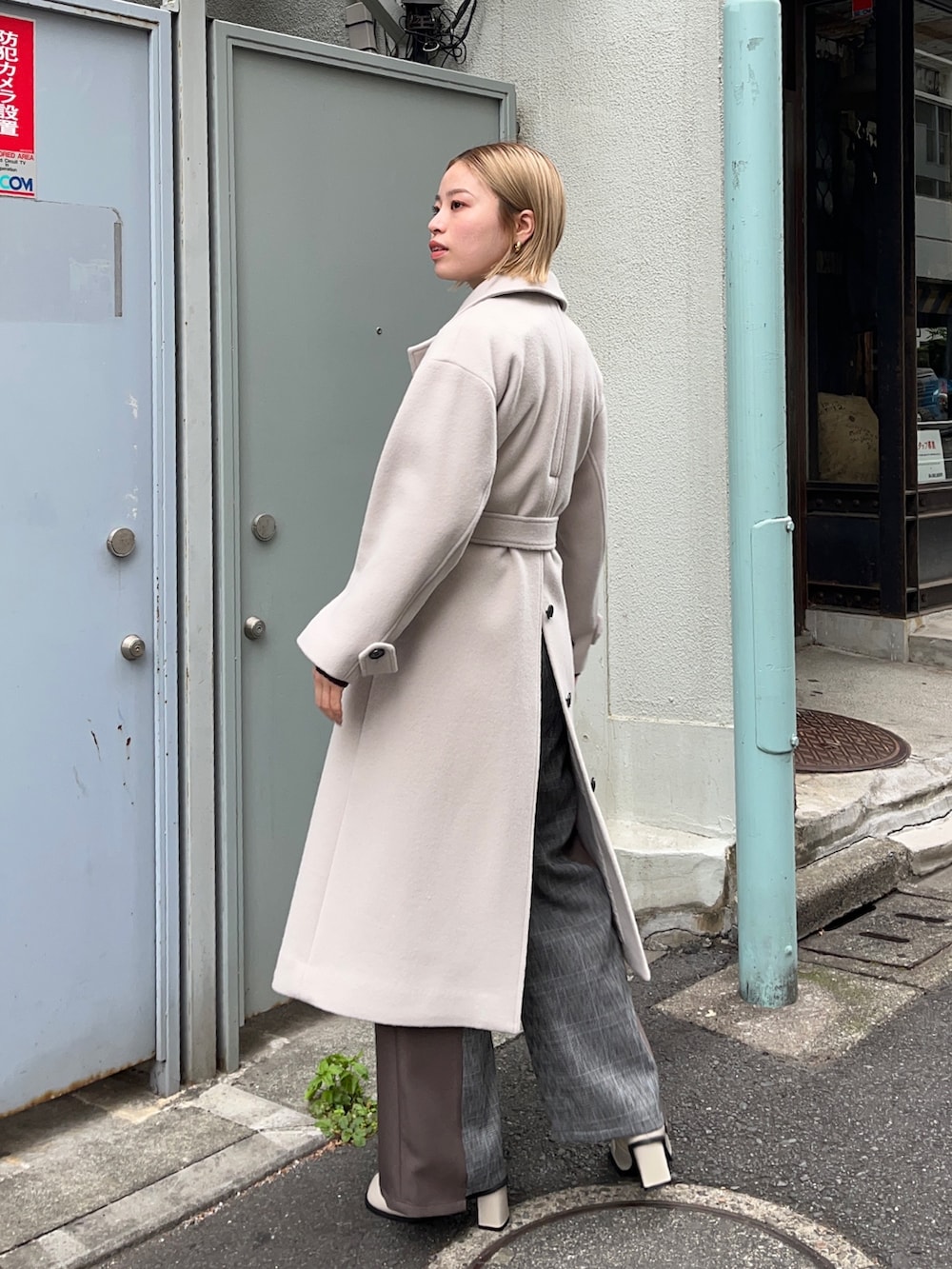 ブラウン系のステンカラーコートを着用したレディースの秋コーディネートの2枚目の写真