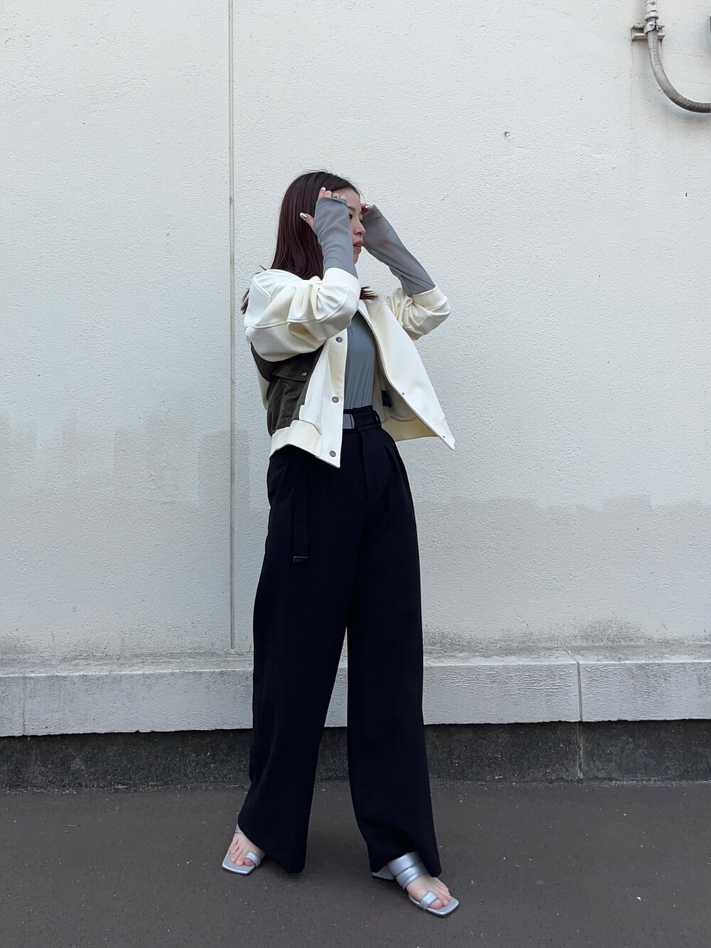 ホワイト系のブルゾン、グリーン系のTシャツ/カットソー、ブラック系のスラックスを着用したレディースの春コーディネートの2枚目の写真