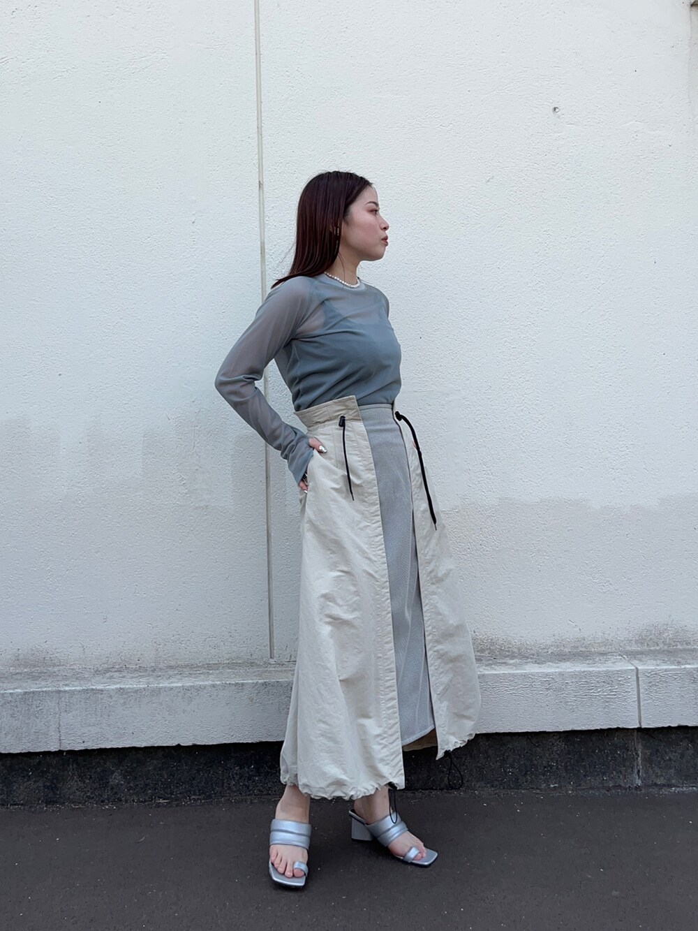 グリーン系のTシャツ/カットソー、ベージュ系のスカートを着用したレディースの春コーディネートの2枚目の写真