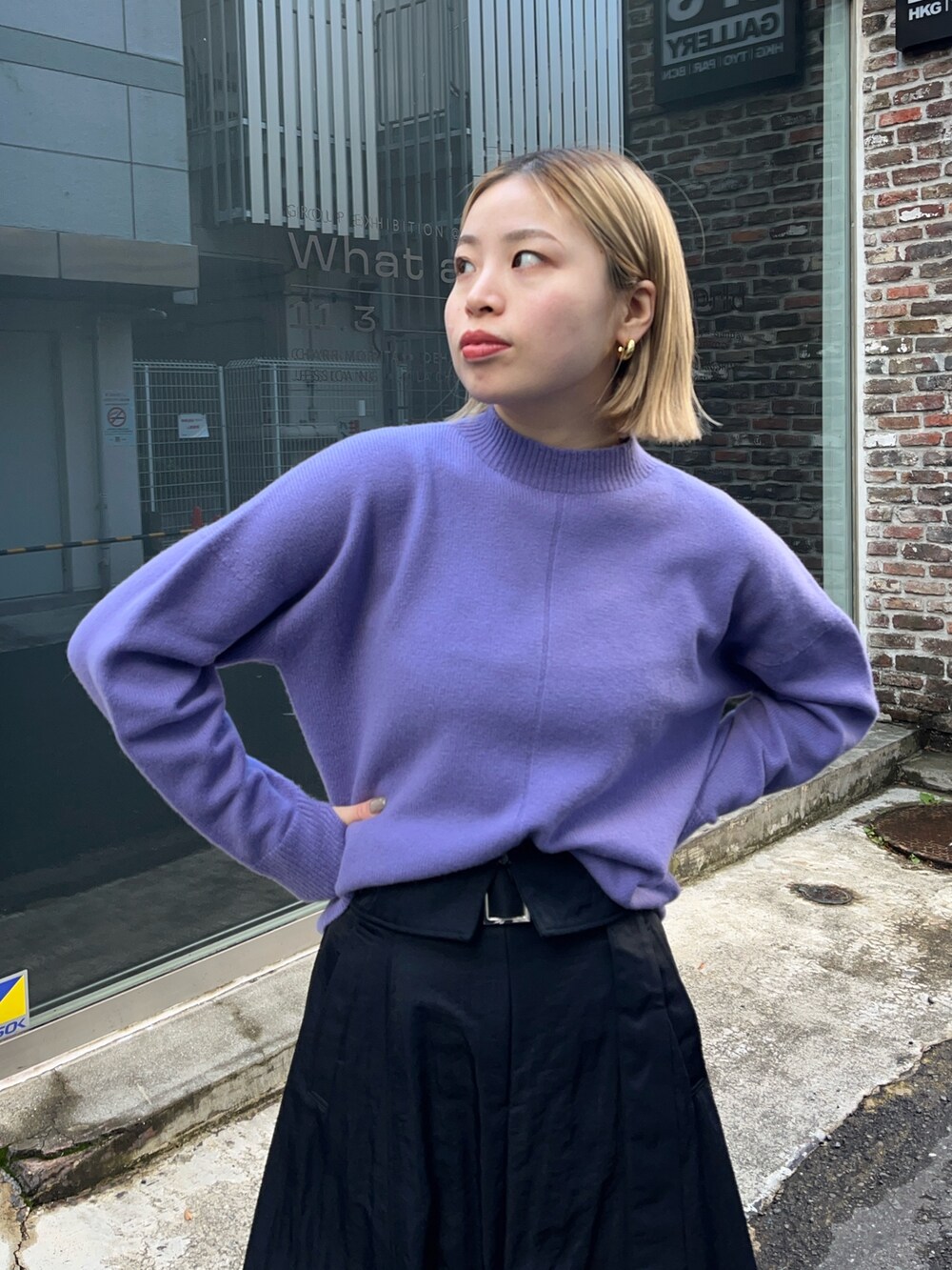 パープル系のニット/セーター、ブラック系のスカートを着用したレディースの冬コーディネートの4枚目の写真