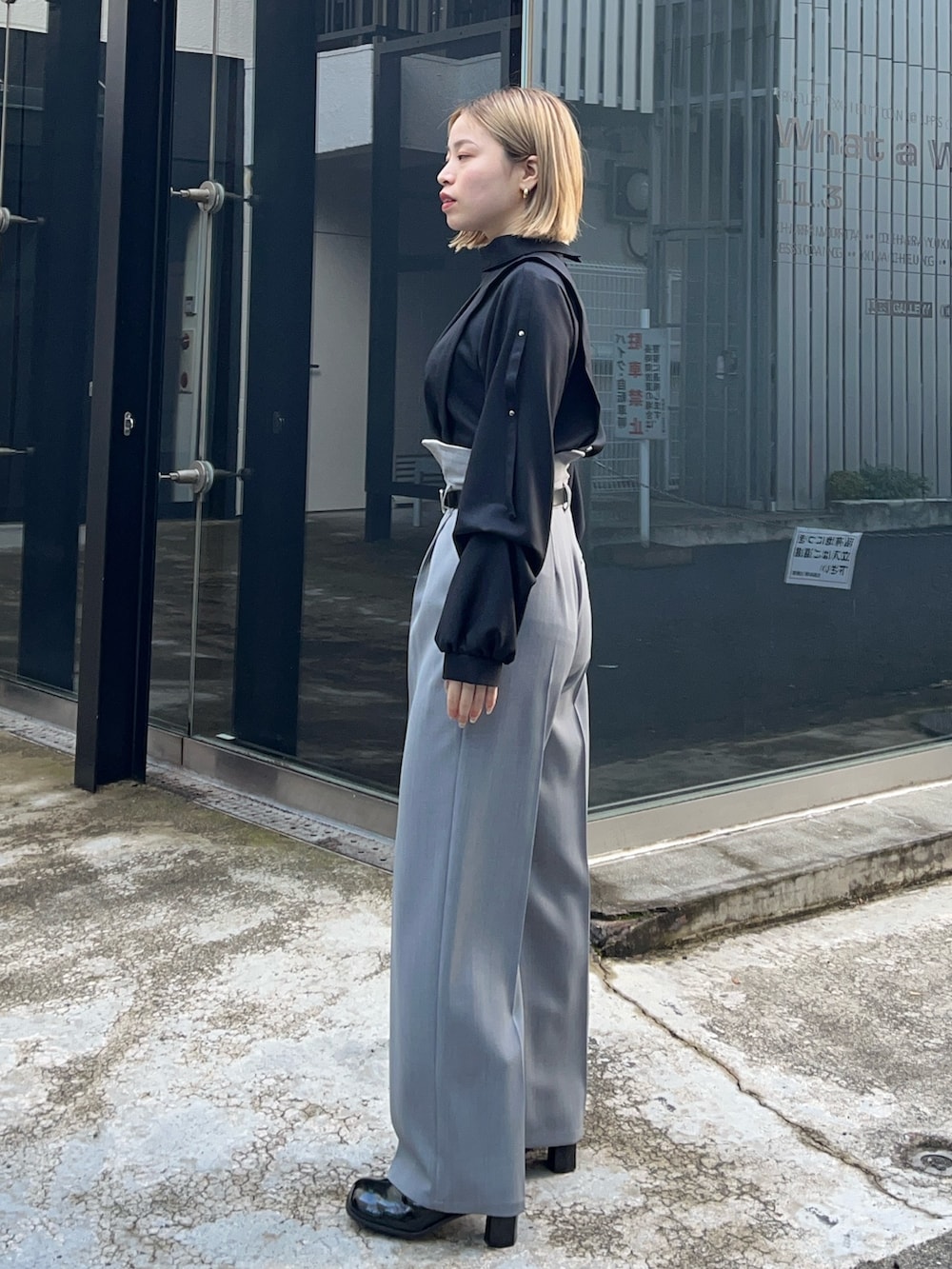 ブラック系のシャツ/ブラウス、グレー系のスラックスを着用したレディースの冬コーディネートの2枚目の写真