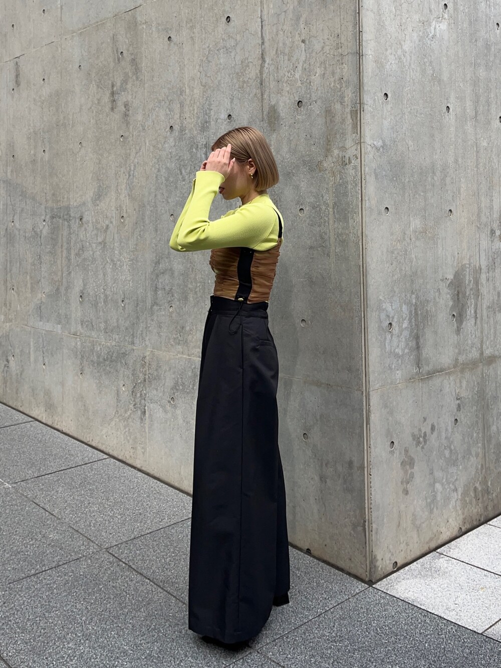 ブラック系のチノパンツ、グリーン系のニット/セーター、ブラウン系のシャツ/ブラウスを着用したレディースの秋コーディネートの3枚目の写真