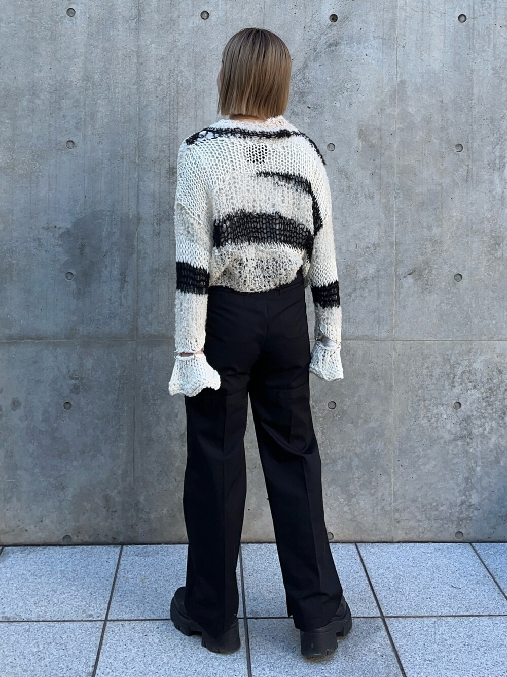 ホワイト系のニット/セーター、ブラック系のその他パンツを着用したレディースの冬コーディネートの3枚目の写真