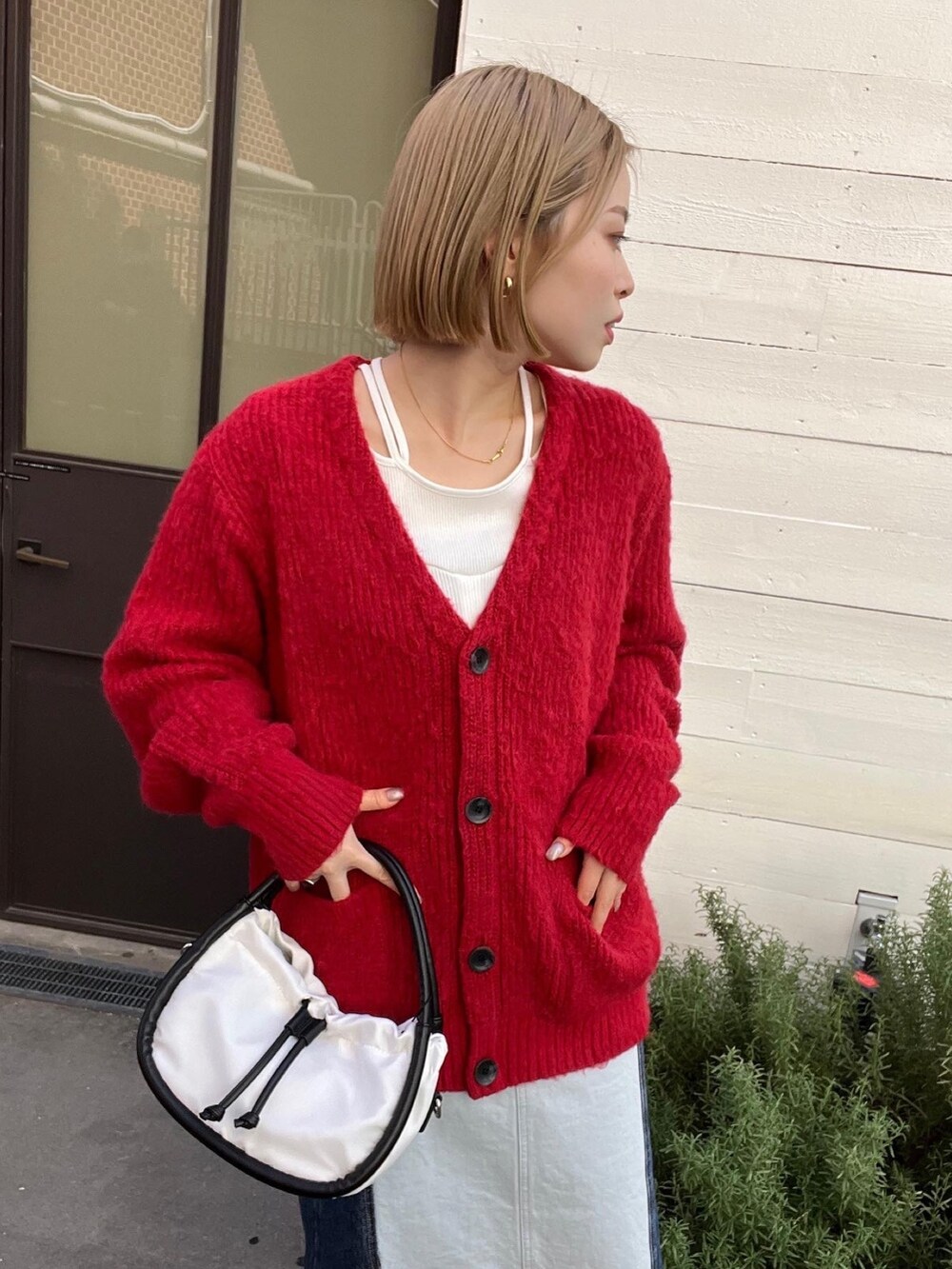 レッド系のカーディガン/ボレロ、ホワイト系のTシャツ/カットソー、ブルー系のスカートを着用したレディースの秋コーディネートの4枚目の写真