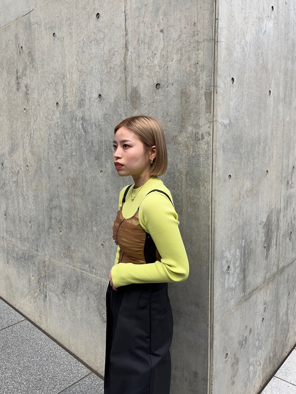 ブラック系のチノパンツ、グリーン系のニット/セーター、ブラウン系のシャツ/ブラウスを着用したレディースの秋コーディネートの5枚目の写真