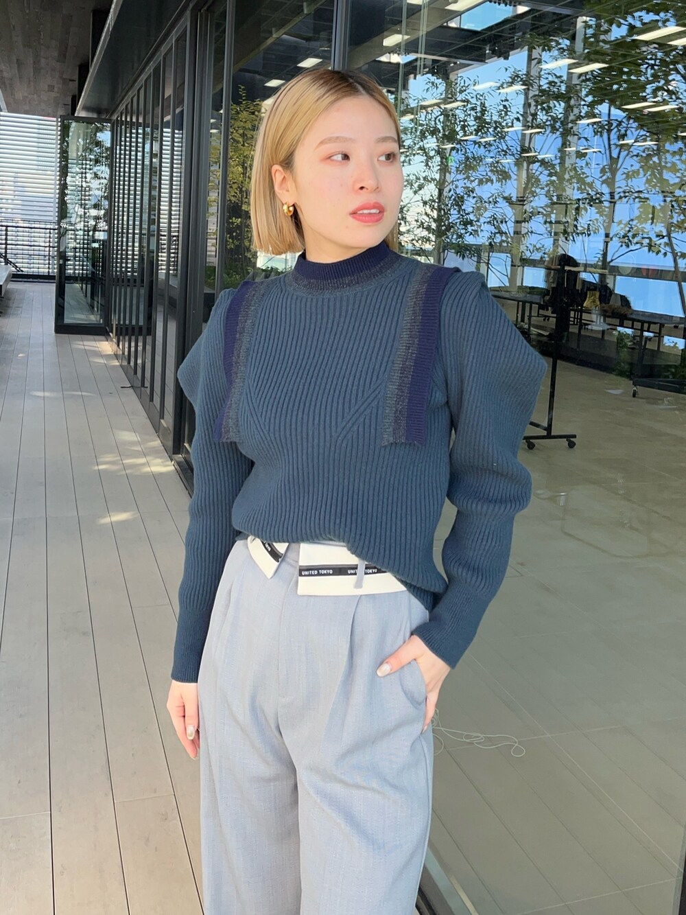 ブルー系のニット/セーター、グレー系のスラックスを着用したレディースの冬コーディネートの4枚目の写真