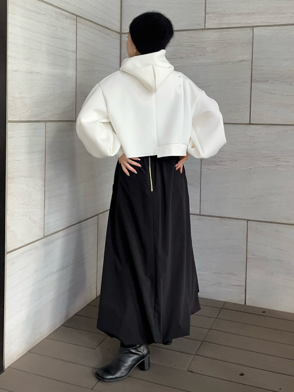 ブラック系のスカート、ホワイト系のTシャツ/カットソーを着用したレディースの冬コーディネートの2枚目の写真