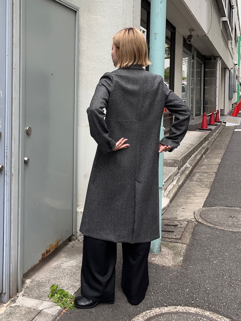 グレー系のチェスターコートを着用したレディースの秋コーディネートの2枚目の写真