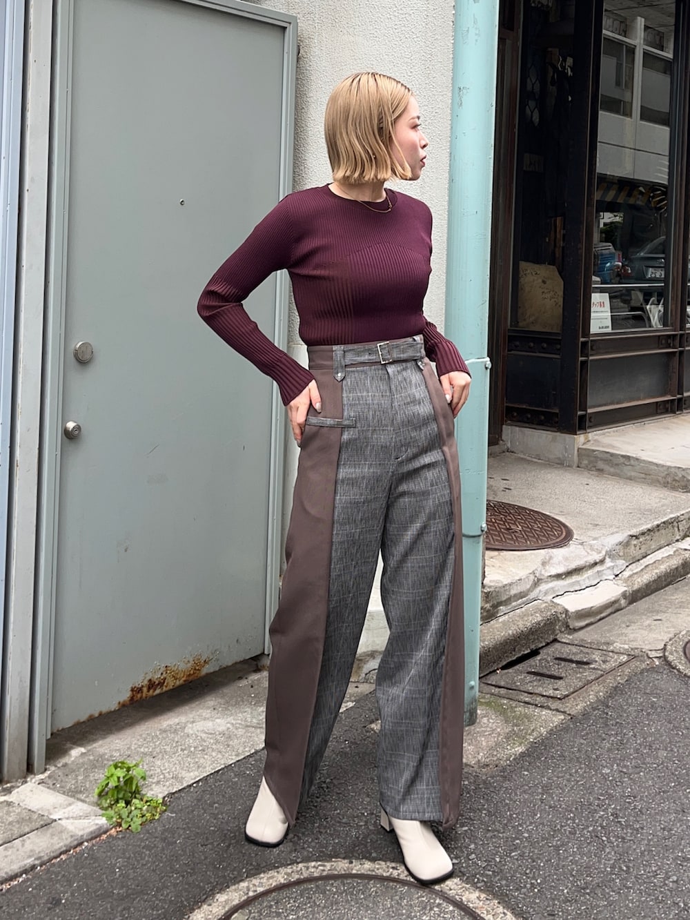 ブラウン系のニット/セーター、ブラウン系のスラックス、ホワイト系のブーツを着用したレディースの秋コーディネートの2枚目の写真