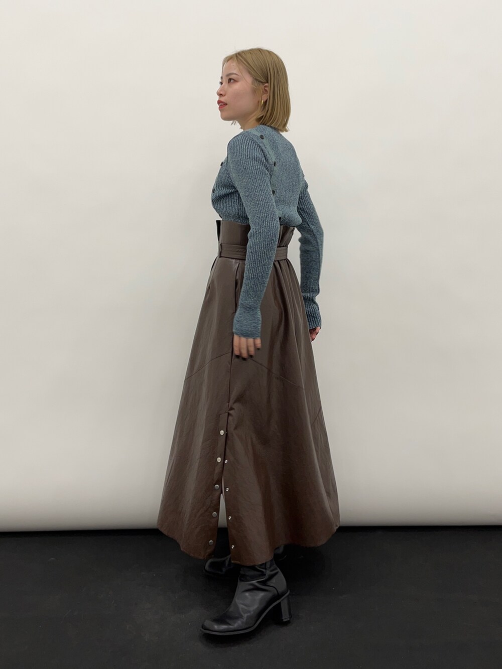 ブルー系のニット/セーター、ブラウン系のスカートを着用したレディースの秋コーディネートの2枚目の写真