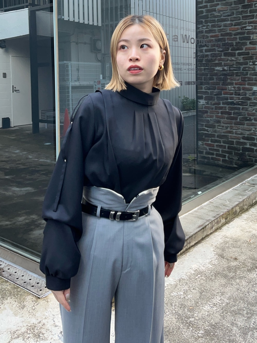 ブラック系のシャツ/ブラウス、グレー系のスラックスを着用したレディースの冬コーディネートの3枚目の写真