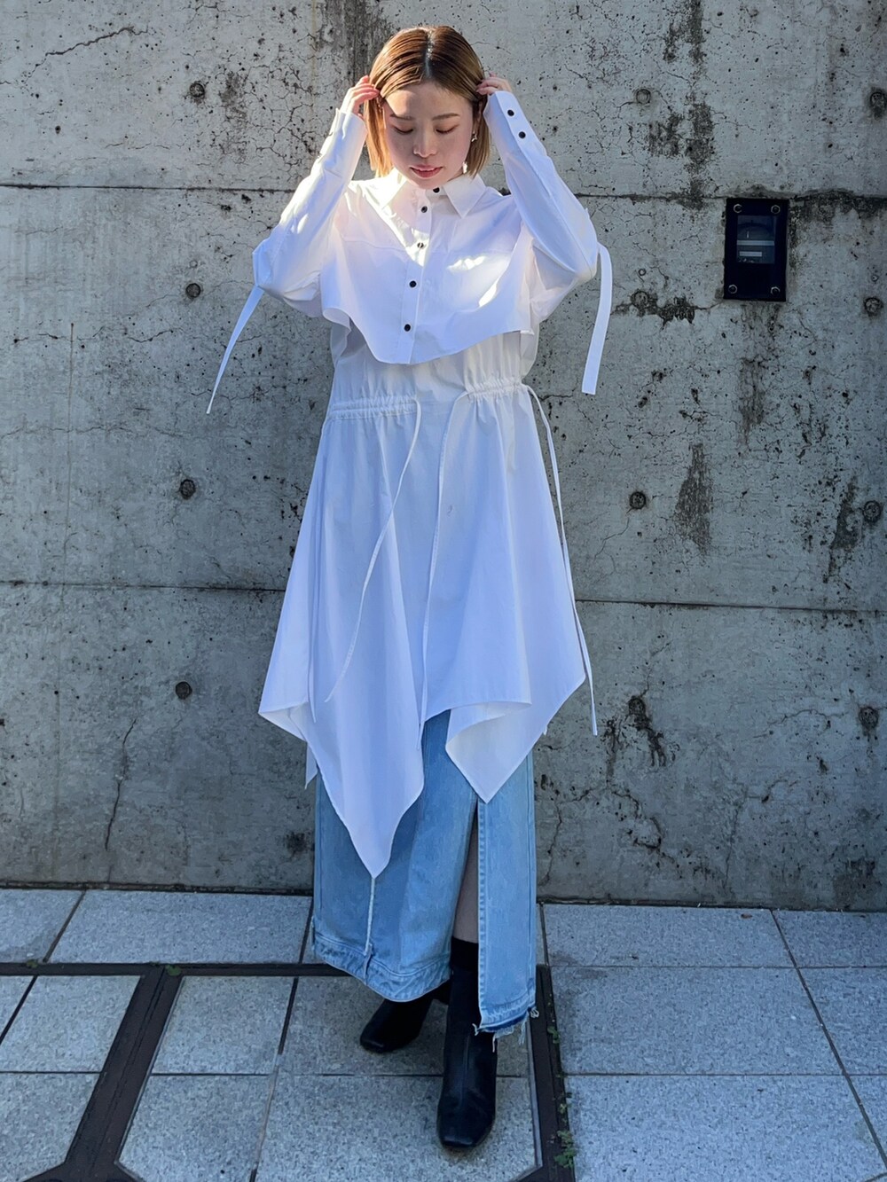 ブルー系のデニムスカート、ホワイト系のシャツワンピースを着用したレディースの冬コーディネートの2枚目の写真