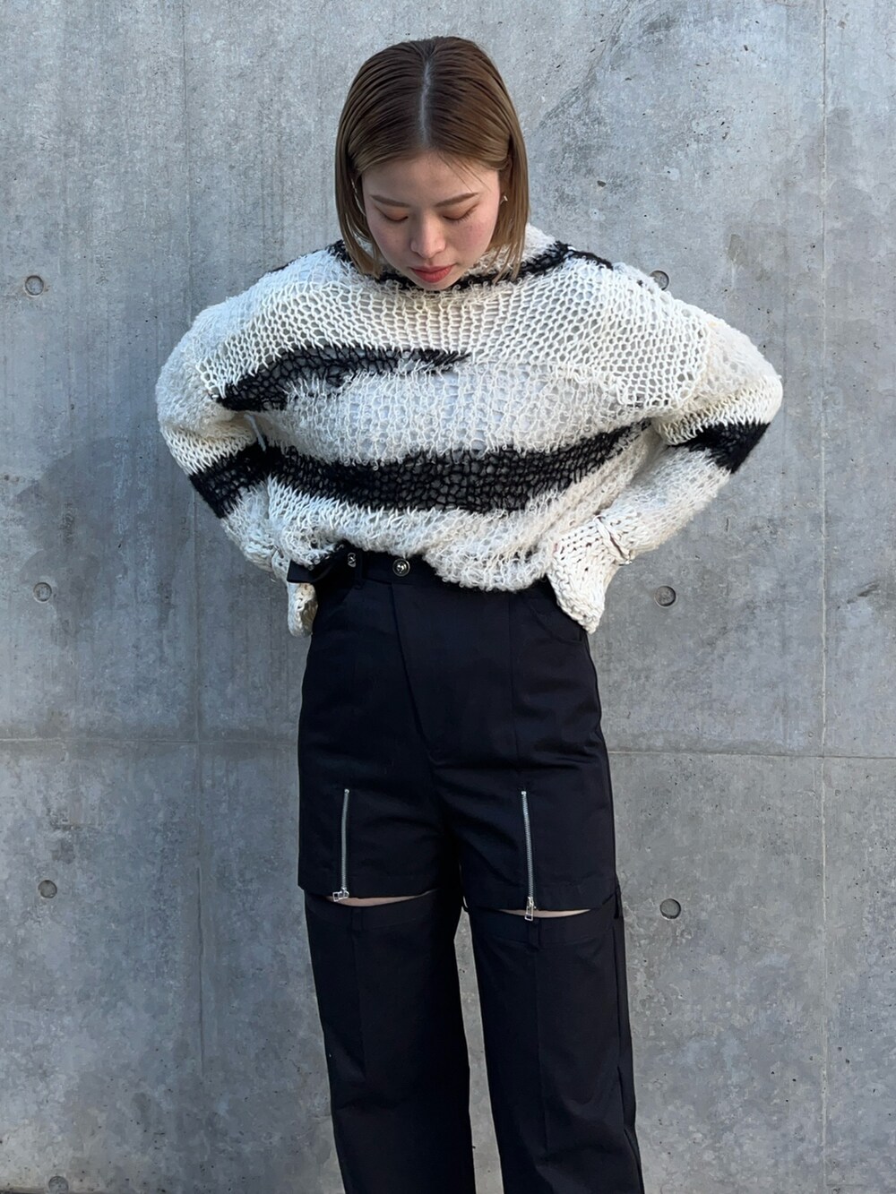 ホワイト系のニット/セーター、ブラック系のその他パンツを着用したレディースの冬コーディネートの6枚目の写真