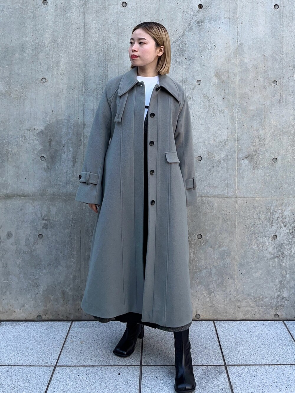 グリーン系のステンカラーコートを着用したレディースの冬コーディネートの2枚目の写真