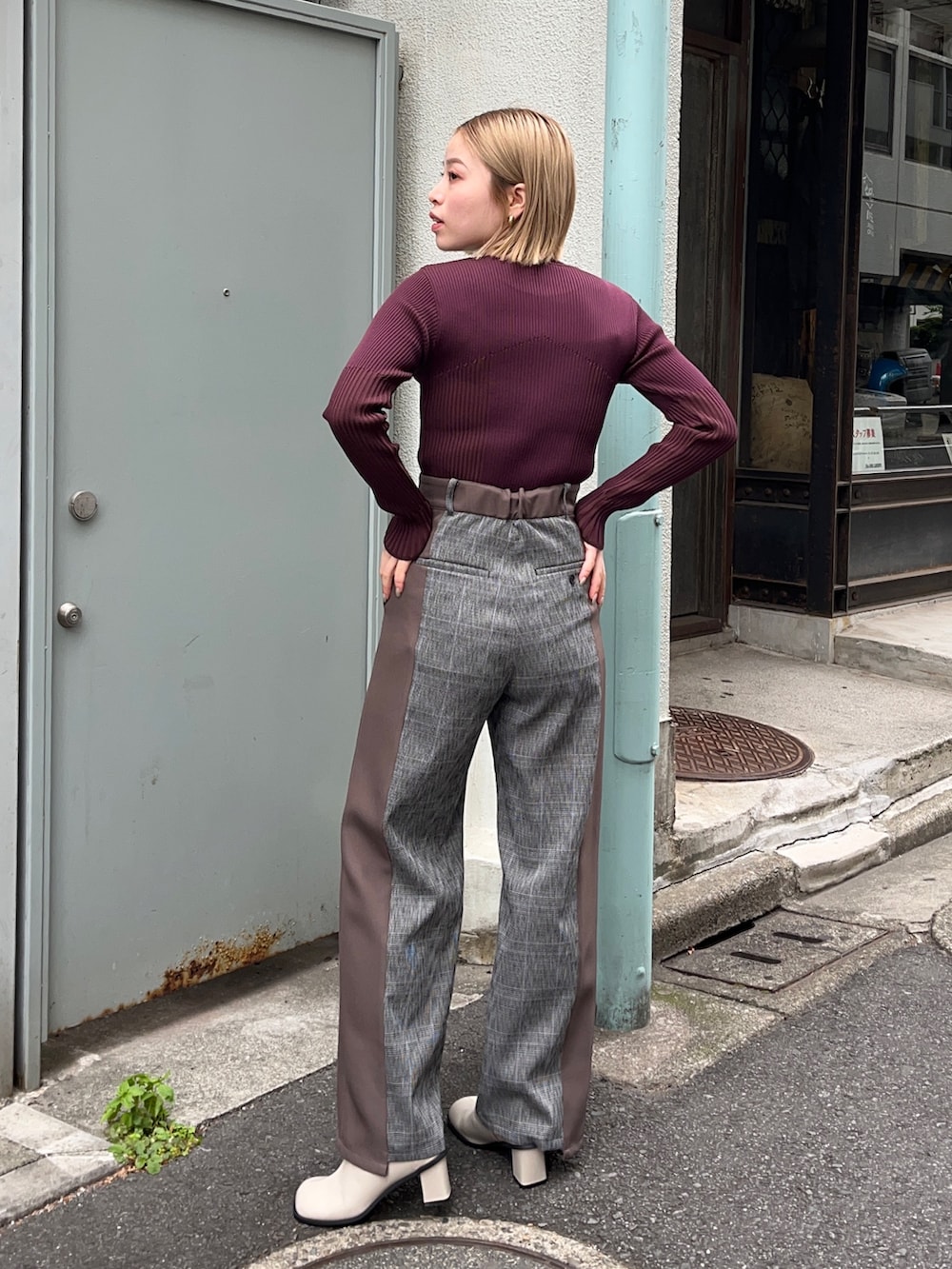 ブラウン系のニット/セーター、ブラウン系のスラックス、ホワイト系のブーツを着用したレディースの秋コーディネートの3枚目の写真