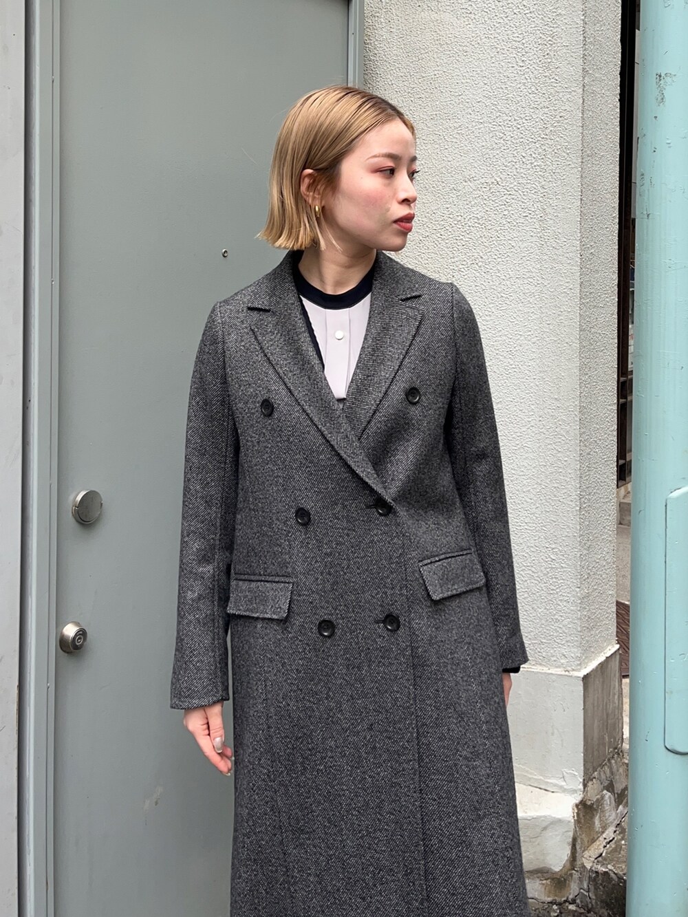 グレー系のチェスターコートを着用したレディースの秋コーディネートの4枚目の写真