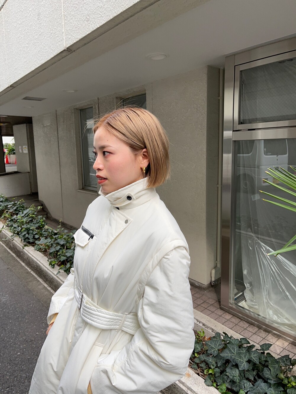 ホワイト系のダウンジャケット/コート、グレー系のニット/セーター、ベージュ系のチノパンツを着用したレディースの秋コーディネートの3枚目の写真