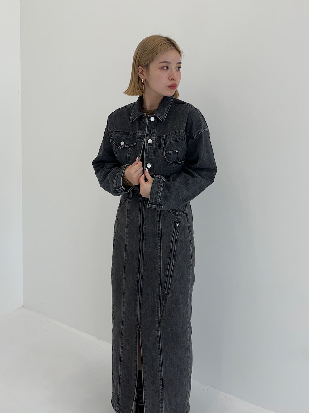 ブラック系のデニムスカート、イエロー系のニット/セーター、ブラック系のデニムジャケットを着用したレディースの秋コーディネートの5枚目の写真