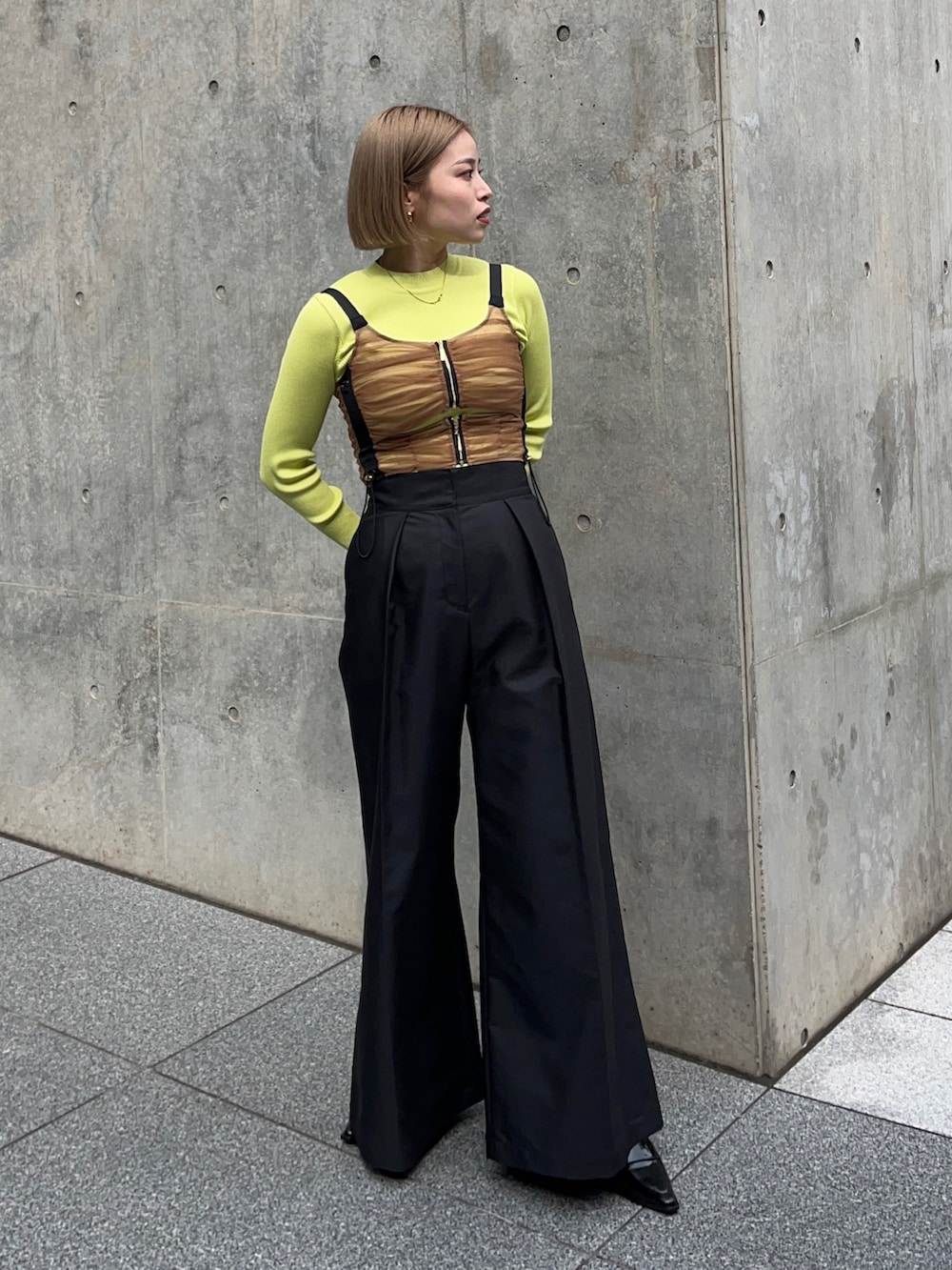 ブラック系のチノパンツ、グリーン系のニット/セーター、ブラウン系のシャツ/ブラウスを着用したレディースの秋コーディネートの2枚目の写真