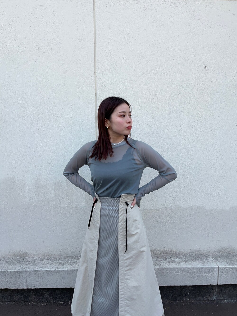 グリーン系のTシャツ/カットソー、ベージュ系のスカートを着用したレディースの春コーディネートの4枚目の写真