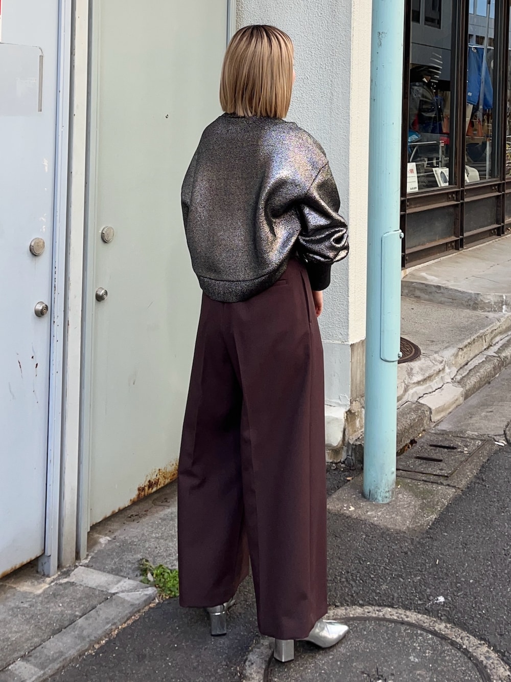 シルバー系のニット/セーター、ブラック系のショルダーバッグ、シルバー系のブーツを着用したレディースの冬コーディネートの3枚目の写真