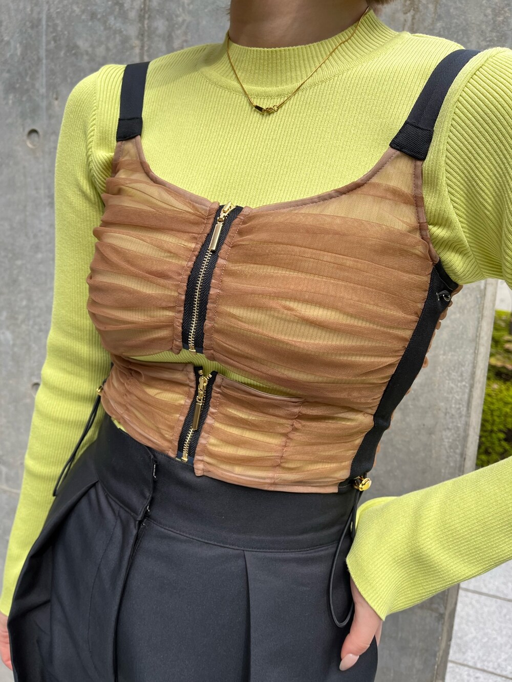 ブラック系のチノパンツ、グリーン系のニット/セーター、ブラウン系のシャツ/ブラウスを着用したレディースの秋コーディネートの4枚目の写真