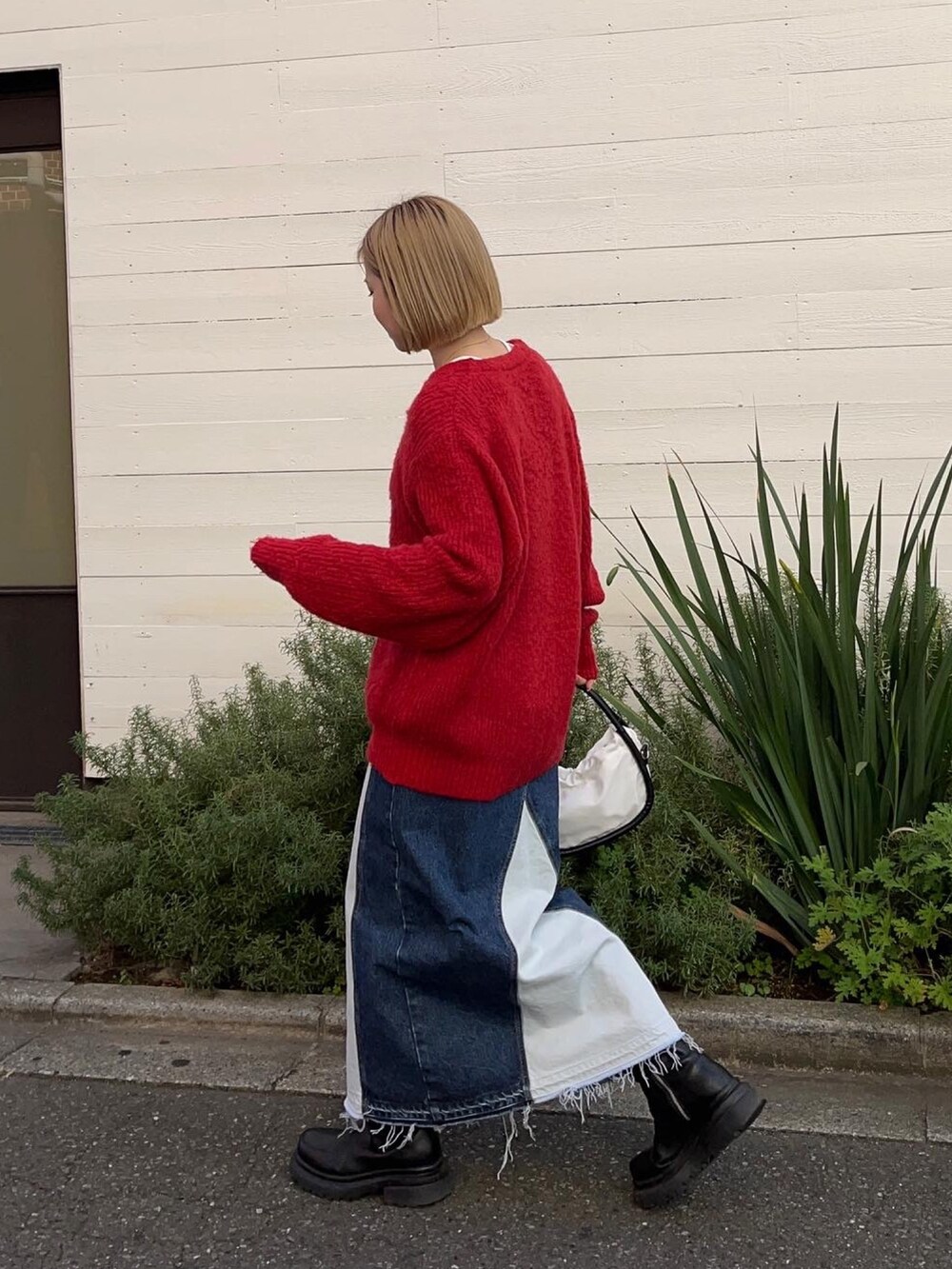 レッド系のカーディガン/ボレロ、ホワイト系のTシャツ/カットソー、ブルー系のスカートを着用したレディースの秋コーディネートの3枚目の写真