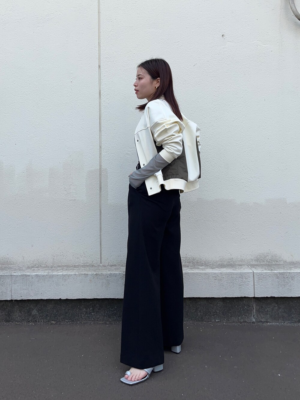 ホワイト系のブルゾン、グリーン系のTシャツ/カットソー、ブラック系のスラックスを着用したレディースの春コーディネートの4枚目の写真