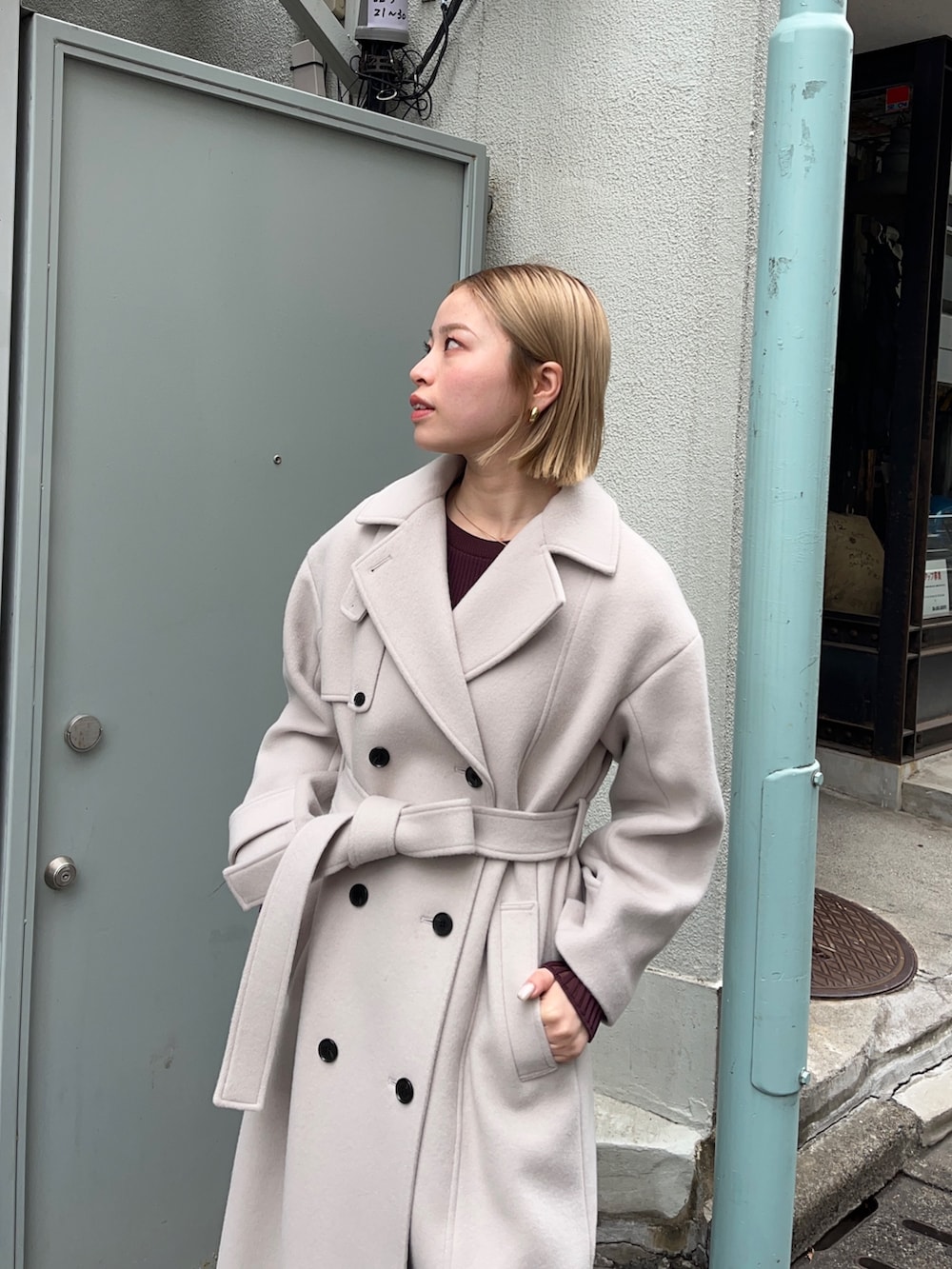 ブラウン系のステンカラーコートを着用したレディースの秋コーディネートの3枚目の写真